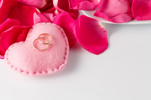 Pétalos de rosa y anillos de boda — Foto de Stock