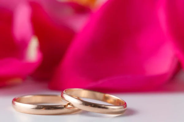 Bagues de mariage dorées avec pétales de rose — Photo