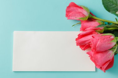 Kağıt arka plan üzerinde metin için kırmızı gül ve boş hediye kartı