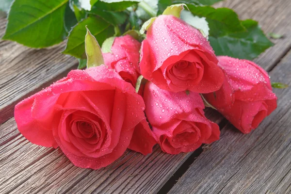 Buquê de rosas na mesa de madeira rústica — Fotografia de Stock