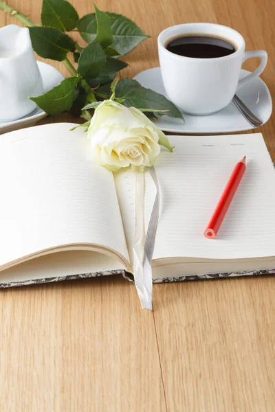 Rose and empty notebook page on wood background — Stock Photo, Image