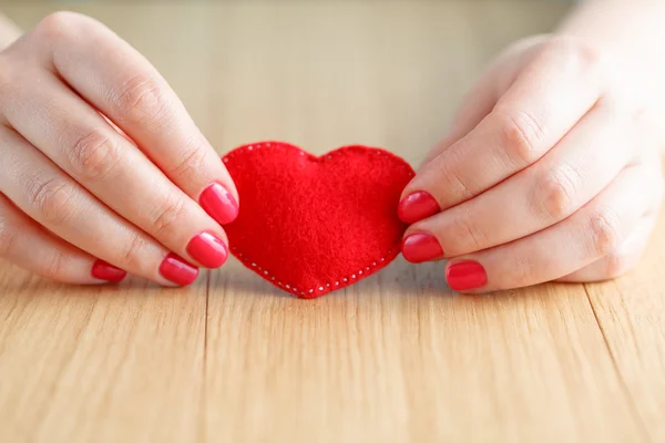 Heart in hands, female holds handmade sewn soft toy — Stock Photo, Image