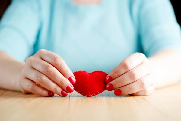 Heart in hands, female holds handmade sewn soft toy — Stock Photo, Image