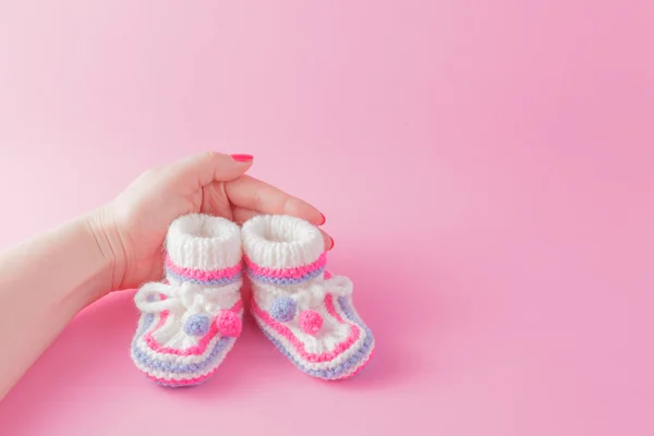 Female hands carefully holing baby shoes — Stock Photo, Image