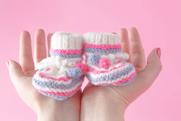 Hembra manos cuidadosamente agujero zapatos de bebé —  Fotos de Stock