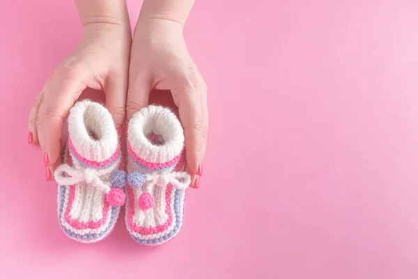 Femmes mains soigneusement holing chaussures de bébé — Photo