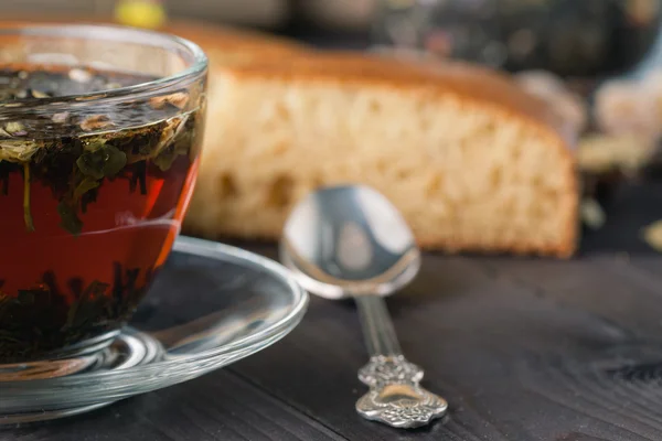 Вареный травяной чай в стеклянной чашке и нарезанный пирог — стоковое фото