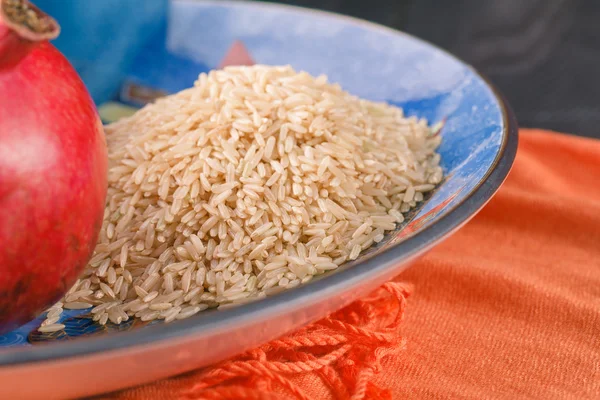 Το ρόδι στα κεραμικά μπολ με καστανό ρύζι — Φωτογραφία Αρχείου