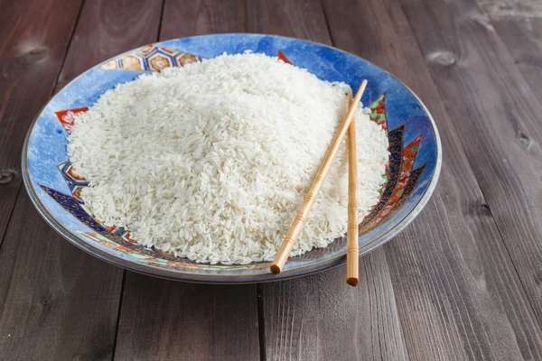 Λευκό ρύζι σε ένα πιάτο, κουτάλι σούπας από την πλευρά — Φωτογραφία Αρχείου