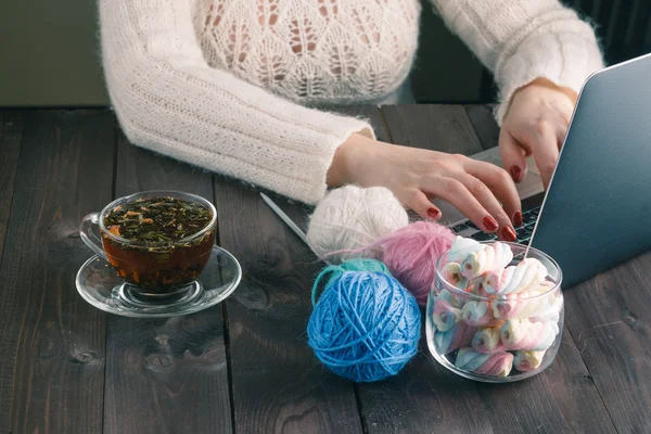 Woman is knitting in front of laptop — Stock Photo, Image