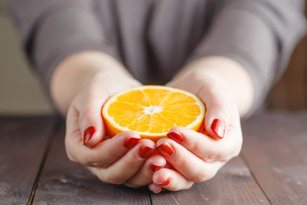 Woman hands holding one half orange — Stock Photo, Image