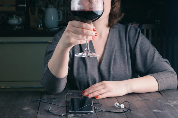 Грустная мыслящая женщина сидит с бокалом красного вина — стоковое фото