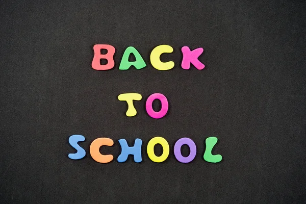 Back to school, written on black board with colorful letters.