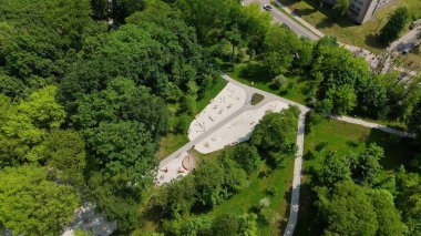 Yeşil şehir ormanındaki açık hava fitness parkı. Yoğun yeşil ağaçlarla çevrili modern bir spor salonu ve fitness parkı ve yürüyüş yolları.