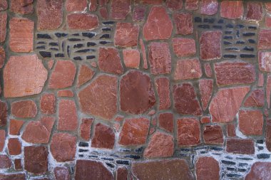 Kırmızı Taş Masonlu Duvar Doku Örnekleri Arkaplanı. Harç eklemleri ve koyu eklemli, mimari doku arka planı olarak ideal kırmızı taştan bir duvarın tam çerçeve görüntüsü