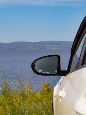 Deniz kıyısında beyaz bir araba..