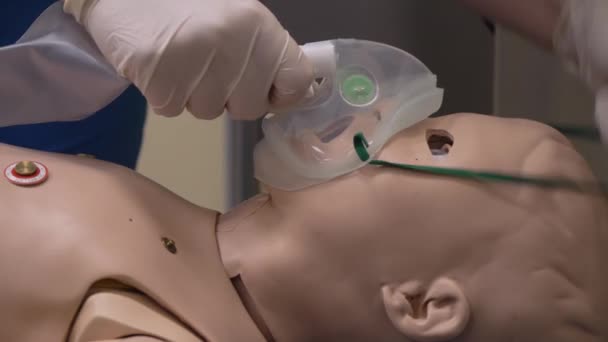 Student lékař pomocí kyslíkové masky na simulaci panenka dítě, close-up — Stock video