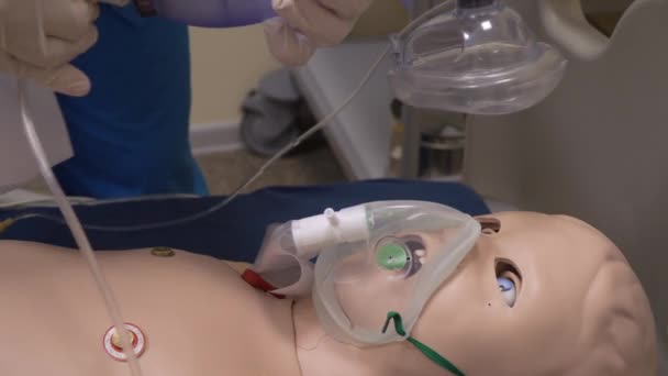 Student lékař pomocí kyslíkové masky na simulaci panenka dítě, close-up — Stock video