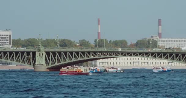 Toeristische boot op de Neva rivier, brug op de rug — Stockvideo
