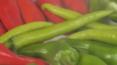 Yeşil ve kırmızı taze biberlerin üzerine su damlacıkları serpmek. Baharatlı yiyecekler. Birbirinin üzerine yerleştirilmiş baharatlı yeşil biberli biberli jalapenoların yakın görüntüsü - biberli yiyecek çeşnisi 