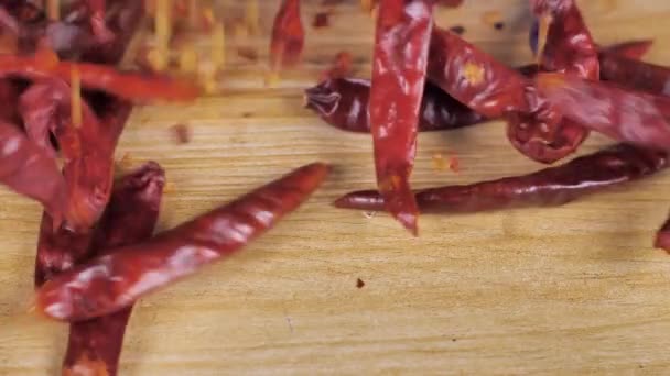 Egzotyczne Płatki Czerwonej Papryki Suszone Całe Chili Spadające Drewniany Stół — Wideo stockowe