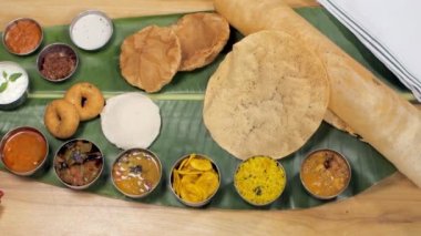 Çeşitli Güney Hindistan yemekleri geleneksel muz yaprağıyla servis edilir. Lezzetli yemekler. Dosa, Poori, Idli, Vada, muz, Payasam ve Raita gibi popüler Güney Hindistan yemeklerini yakından çektik.