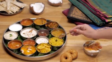 Güney Hint vejetaryen Thali 'den limonlu pirinç ısırığı alan kadın eller. Limonlu pilav, Sambhar, muz cipsi ve Chutney gibi popüler yemeklerin yakın plan çekimi ipek sarilerle bir arada tutulur.