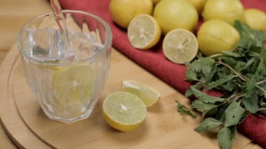 Nane yapraklı sağlıklı buzlu limon suyu bir bardağa dökülür. Soda, limon ve Pudina 'nın limonata hazırlamak için ayrıldığı serinletici içeceği yakından çek.