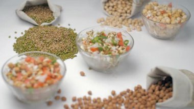 Soğan, domates ve biberle karıştırılmış nohut salatası. Bir kase yeşil Moong Dal ve domates ve biberle süslenmiş Bengal gramıyla dolu bir çuval.