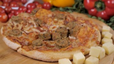 Kurutulmuş kırmızı biber taneleri lezzetli bir tavuklu pizzanın üzerine dökülüyor. Kırmızı ve sarı dolmalık biberli ve vişneli lezzetli vejetaryen olmayan bir pizzanın aşırı yakın plan çekimi.