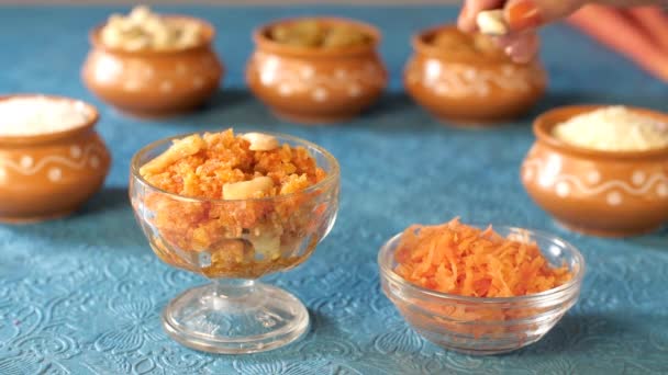 女子的手将干果 Kaju添加到新准备的Gajar Halwa中 传统的印度甜食 加贾尔 哈尔瓦 配以烤胡萝卜 盖伊和干果 — 图库视频影像