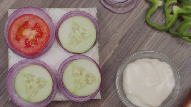 サンドイッチを作るために白いパンにトマトのスライスを置く女の子 — ストック動画