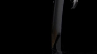 Çözünür hap / tabletin suyla bardağa düşme / düşüşünün üst görüntüsü. Saf bir bardak suda koyu bir arka planda eriyen coşkun hapın yakın plan çekimi.