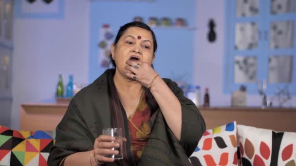 Stara Hinduska Kobieta Bierze Pigułki Siedząc Sofie Opieka Zdrowotna Emerytura — Wideo stockowe