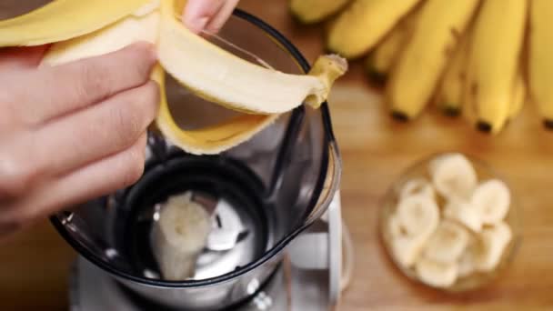 Vrouwelijke Hand Schillen Van Een Banaan Breken Stukken Een Blender — Stockvideo