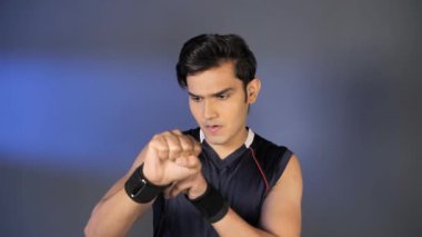 Hint erkek boksör yirmili yaşlarının başında kickboks eğitimi için bilekliklerini düzeltiyor. Kolsuz tişörtlü, kendine güvenen ve güçlü bir sporcunun orta boy fotoğrafı. Sağlıklı yaşam tarzı konsepti.