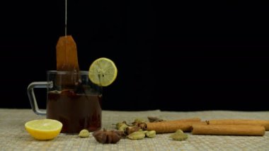Bir fincan aromatik yeşil çay yapmak için sıcak suya batırılmış çay poşeti. Hint baharatlı kakule, tarçın ve yıldız anason ile bir fincan sağlıklı limon çayı hazırlıyorum.
