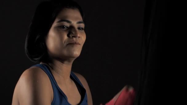 女拳击手在准备跆拳道训练的时候打了一袋拳 年轻的短发女运动员头戴红色运动绷带练习打拳的特写 健康而积极的生活方式 — 图库视频影像