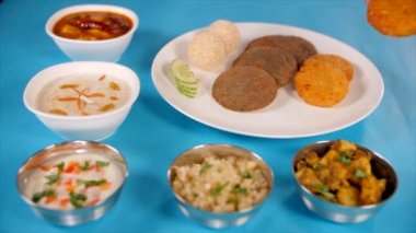 Navratri için hazırlanmış enfes Upwas yemekleri servis eden Hintli bir kadının eli. Hindistan 'da Navratri' de servis edilen tabaklar ve kâselerde sunulan güzel Hint yemekleri yakın plan çekimleri.