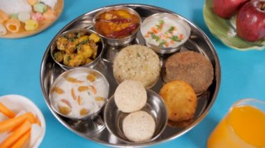 Pikapta dönen Navratri thali / tablasının yakın plan çekimi. Navratri 'de dini Upwas / oruç günlerinde servis edilen geleneksel Kuzey Hint yemeklerinin yüksek açılı çekimi