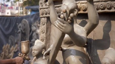 Tanrıça Lakshmi, Parvati ve Saraswati 'nin putlarına boya sıkan sanatçı. Tilt shot - Ma Saraswati, Parvati ve Lakshmi heykellerini çizen Hintli profesyonel bir zanaatkarın elleri