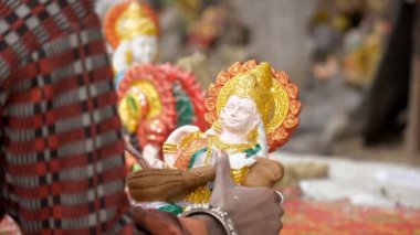 Bayan bir sanatçı güzel bir şekilde Ma Saraswati 'nin kil heykelini ibadet için bitiriyor. Hint festivali için Hint Tanrıçası Saraswati 'nin kil heykelinin ellerini boyayan kadın zanaatkar.