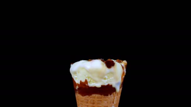 バタースコッチ風味のアイスクリームコーンをキャラメルで溶かすタイムラプスショット バタースコッチ風味のアイスクリームコーンのクローズアップショット黒を背景に高速で溶融 — ストック動画