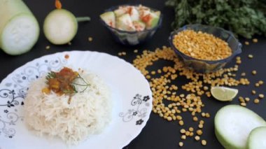 Ev yapımı lezzetli Lauki Sabzi / köri bir tabak pirinç ve taze Dhania üzerine düşüyor. Bir dilim limon olan çiğ Chana Dal 'ın yakın plan çekimi için Doodhi, mutfak alanında bir arada tutuluyordu.