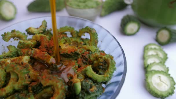 在Karela切片上倒入的油与Haldi混合制成Achaar Indian配方 用切碎的西瓜片 卡雷拉酱和蔬菜汁与白底混合制成的特写照片 — 图库视频影像