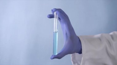 Health worker's hand with a test tube and researching medicine for the treatment. Closeup shot of a scientist wearing gloves for safety purpose testing Coronavirus medicine in the lab 