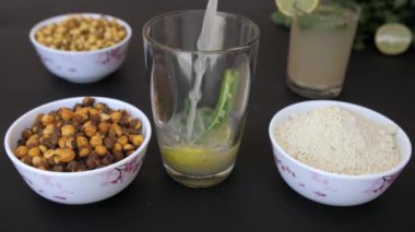 Yaz içeceği Sattu, bir dilim limon, Dhania ve bir bardak kırmızı biber. Siyah Chana, beyaz Channa, Sattu unu, dilimlenmiş limon ve kişniş yapraklarının yakın plan çekimi.