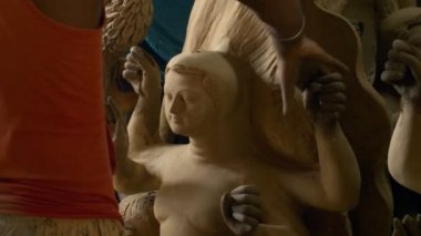 Önümüzdeki Durga Puja festivali için Ma Durga heykelleri yapan bir zanaatkar. Hintli bir sanatçının elleri, el sanatları fabrikasında Hindu tanrıçası Durga 'nın kil heykelini şekillendiriyor.
