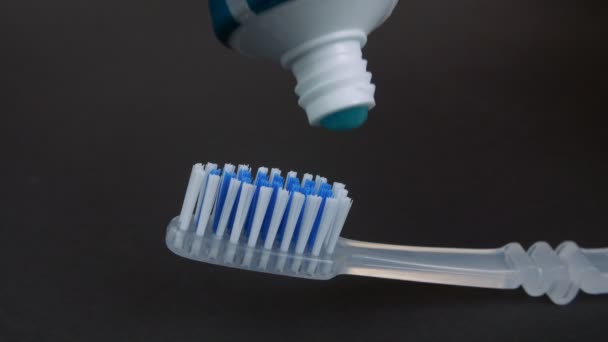 Ściskanie Rozprowadzanie Lub Nakładanie Niebieskiej Pasty Szarą Szczoteczkę Zębów Zbliżenie — Wideo stockowe