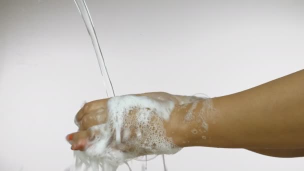 一名印度女性洗手以防止考拉韦病毒感染 一个剪裁过的女人用自来水在白色背景下冲洗肥皂泡手的侧视图照片 — 图库视频影像